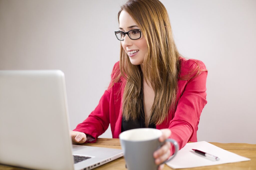 Frau blickt in Computer und ist im intensiven Gespräch. Mit Onlinecoaching können Sie individuell Termine wahrnehmen.